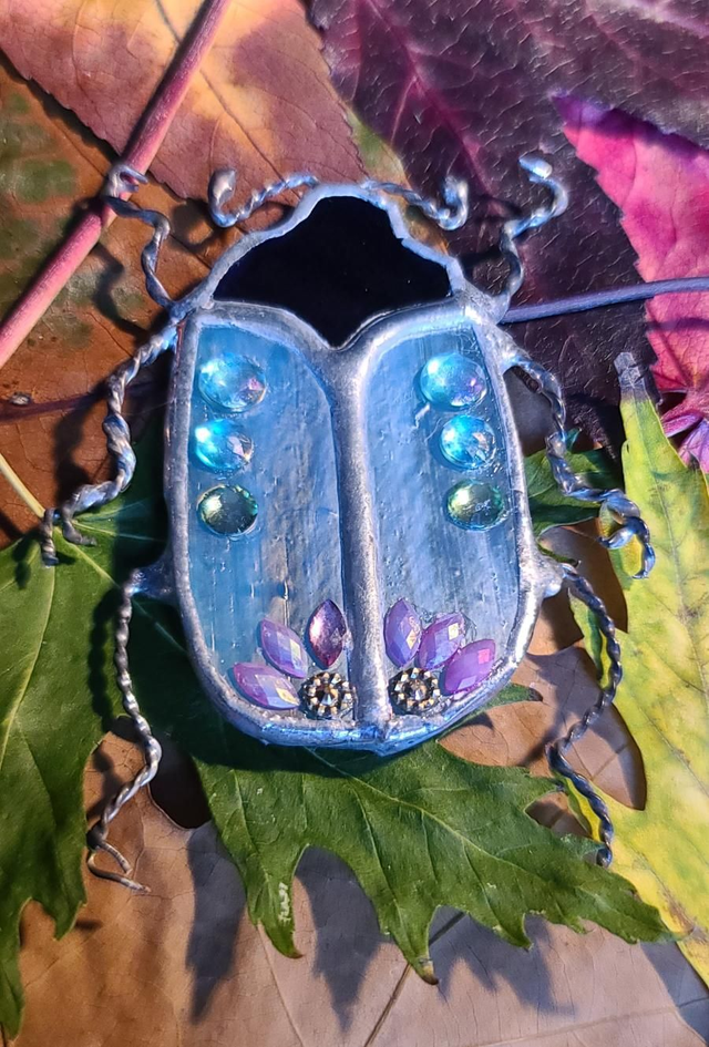Scarabée en Tiffany au corps bleu iridescent et à la tête noire en magnet .