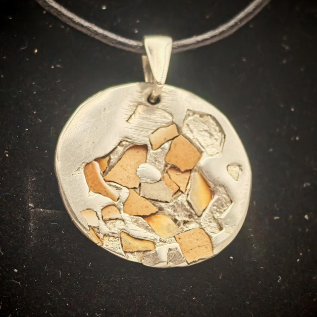 Pendentif de coquille incrusté dans métal en fusion