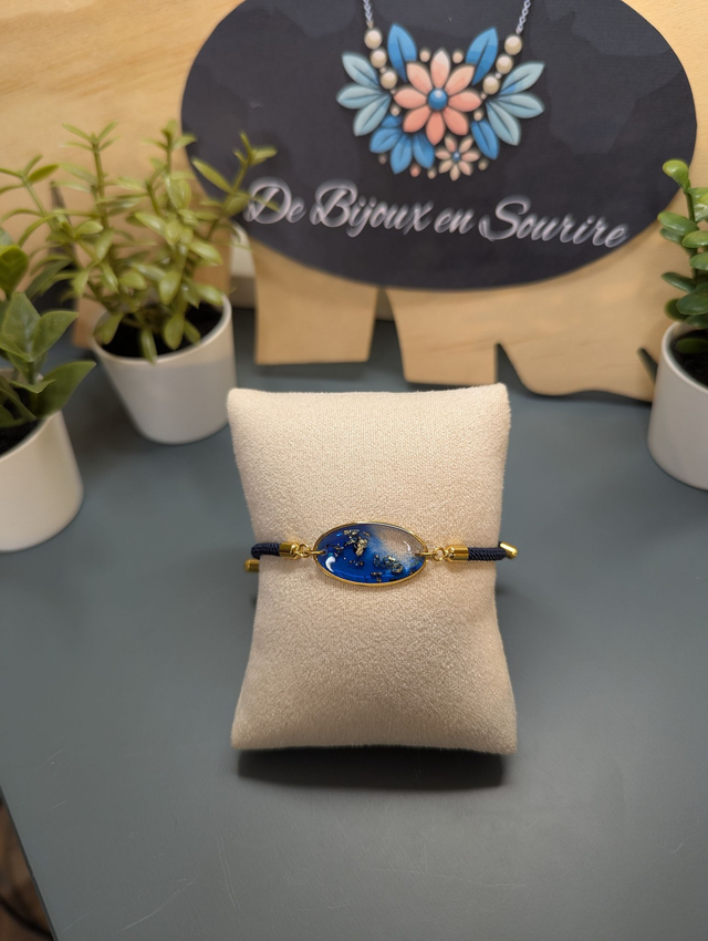 Bracelet corde ajustable bleu foncé et pendentif ovale en résine.