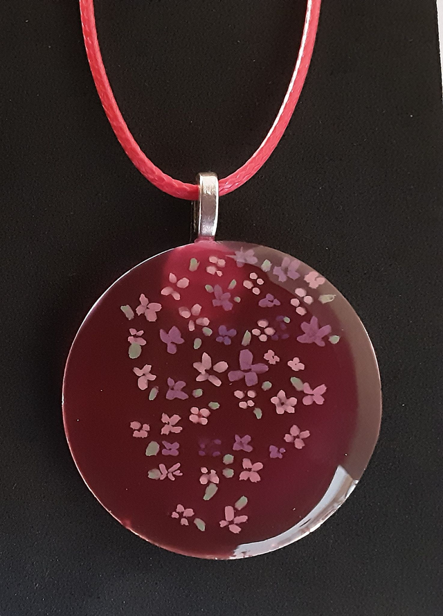 Pendentif rond collection Floral fond framboise translucide parsemé de petites fleurs rose et mauves