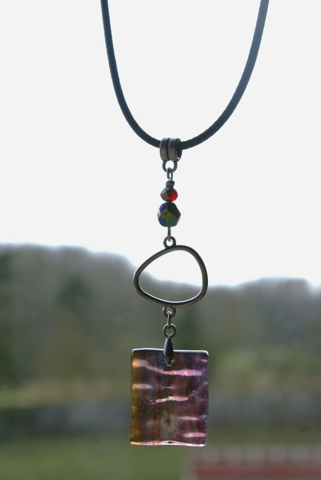 Pendentif en verre chamarré violet et prune transparent et chaîne en coton ciré noir.