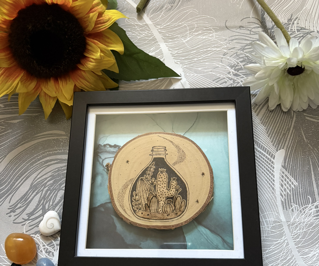 Framed silver birch slice with cacti in a jar design. 