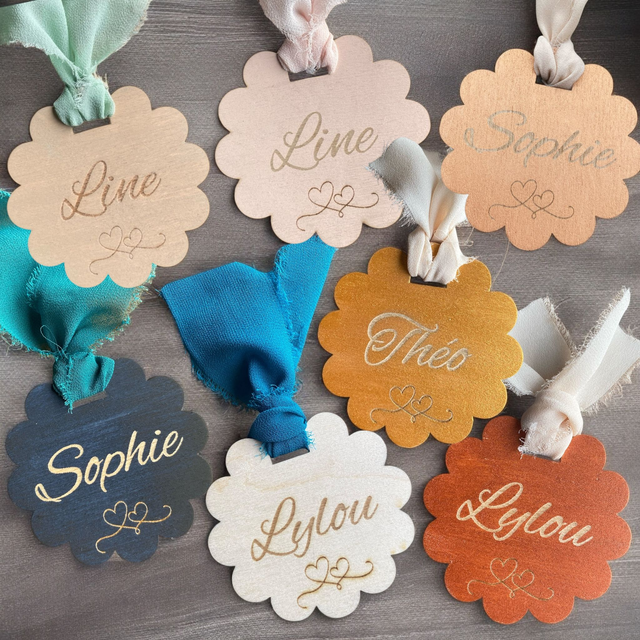 Marque-place en bois peint en forme de fleur avec son ruban