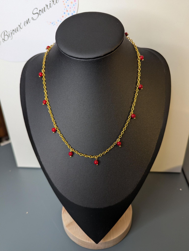 collier court chaine en or fine et des perles naturelles de couleur rouge, la chaine fermoir est de couleur or. 