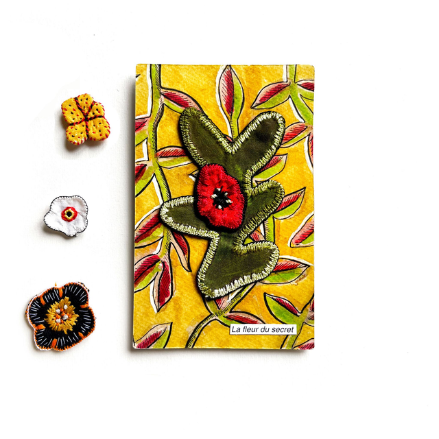 Tableau végétal peint et orné de broderies (rouge et kaki).