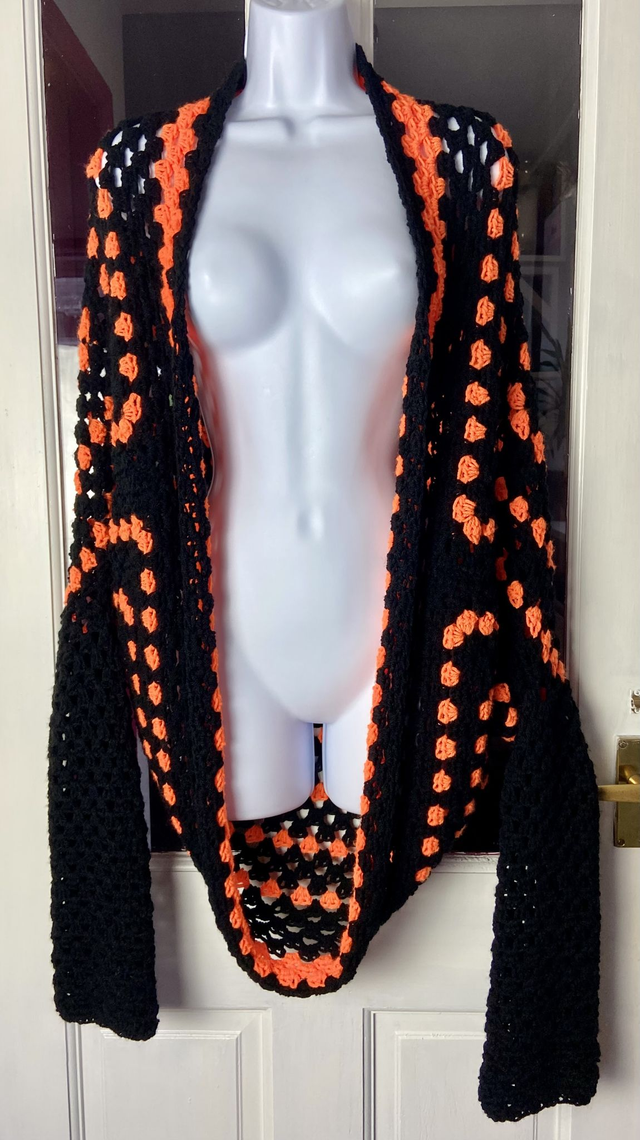 Orange and black shrug style cardigan.