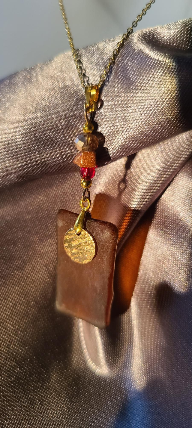 Pendentif en verre brun caramel dépoli et chaîne couleur or. 