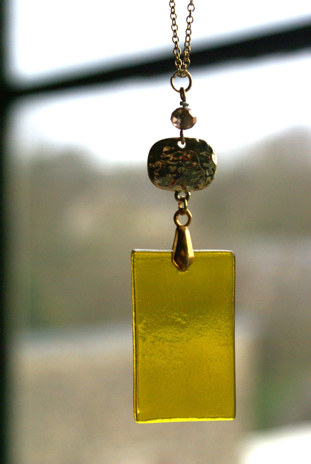 Pendentif en verre jaune et chaîne en coton ciré noir. 
