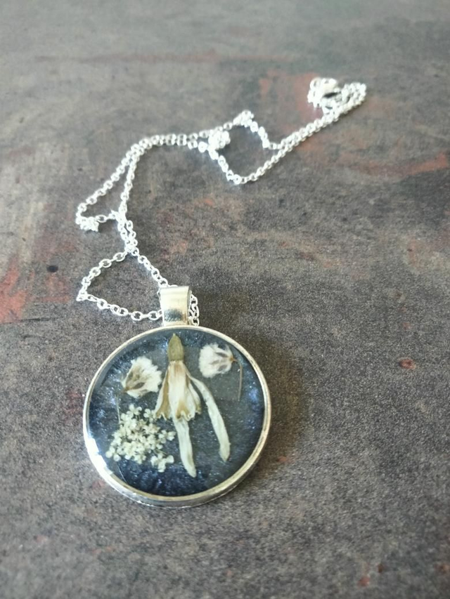 Pendentif forme ronde couleur argent avec inclusion de fleurs séchées 