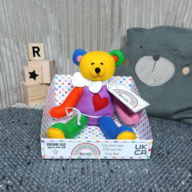 Rainbow. Medium size, handmade teddy bear. UKCA. Tray base packaging. Standard Wool Felt. Yellow. Red. Blue. Green. Purple. Orange. Pink. White. Grey.
