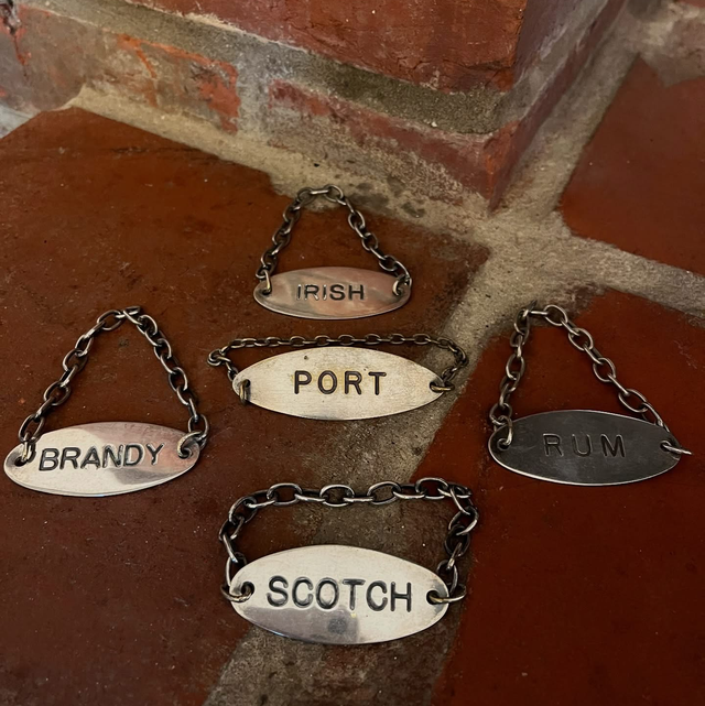 A Set Of Five Silver Plate Decanter Lables