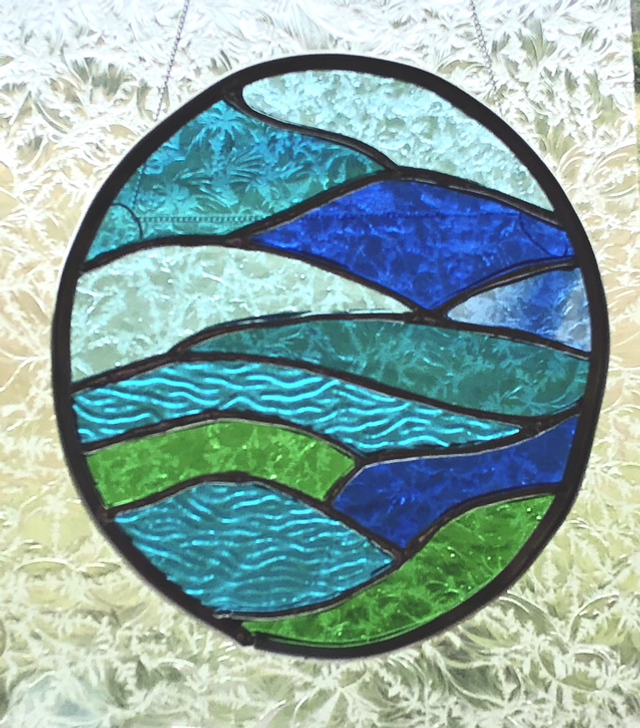 Abstract of hills, water, sky and cornfields