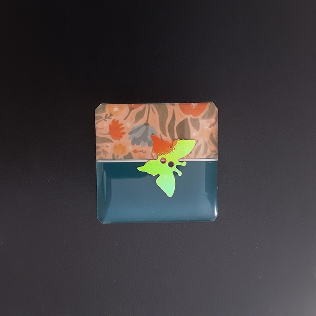 Broche petit carré collection floral fond bleu pétrole avec décor floral et papillon scintillant