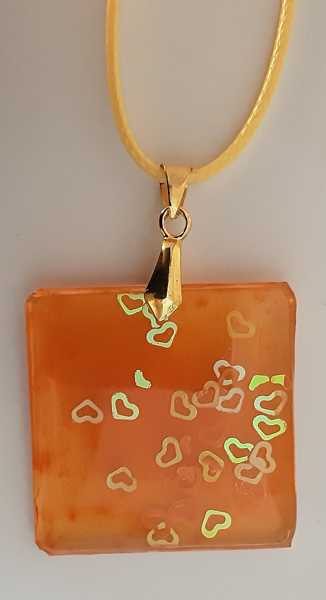 Pendentif petit carré collection Mouna paillette fond orange translucide et petits coeurs irisés