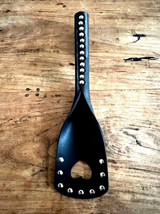 Handgemaakte plak met hartje van zwart tuigleer met houten handvat.