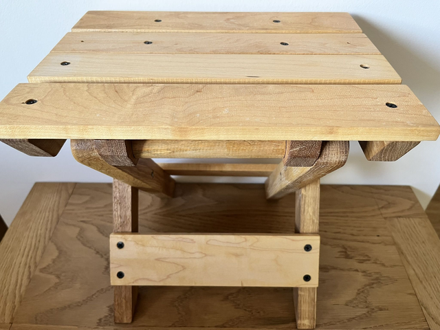 Wooden, folding camping stool made of oak and maple wood.
