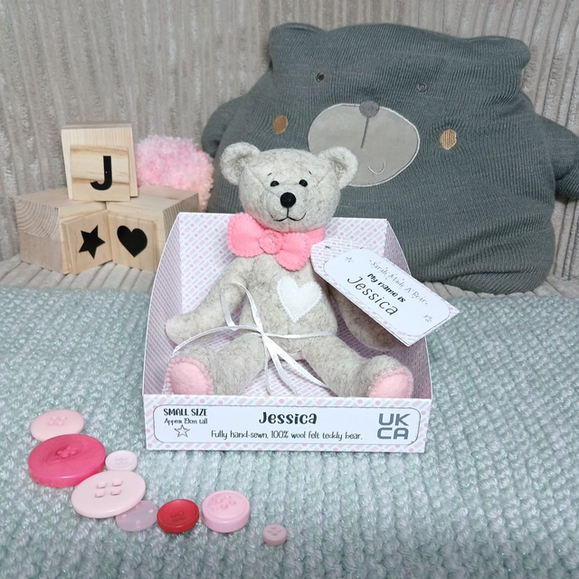 Jessica. Small size, handmade teddy bear. UKCA. Tray base packaging. Standard Wool Felt. Fluffy beige. Baby pink and bright pink. White.