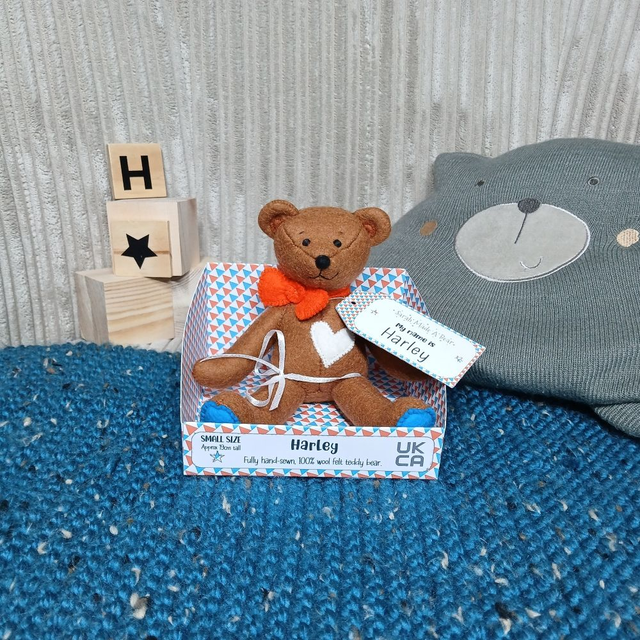 Harley. Small size, handmade teddy bear. UKCA. Tray base packaging. Standard Wool Felt. Brown. Orange. White. Blue.