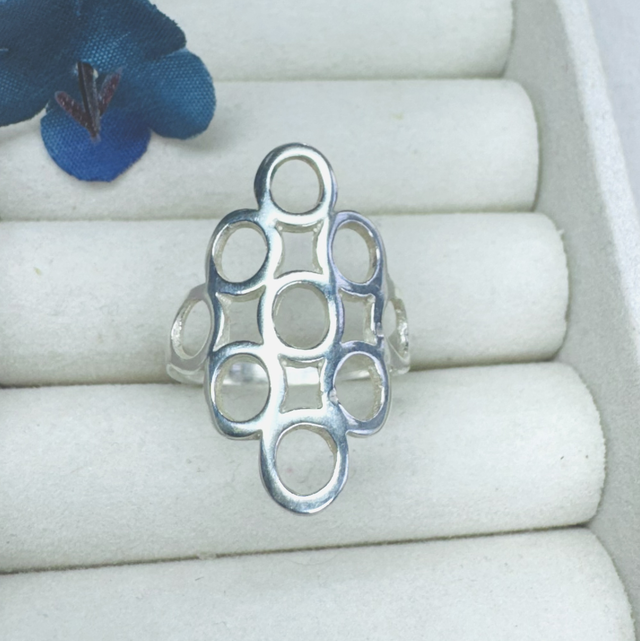 Anel maximalista triangular com círculos vazados 