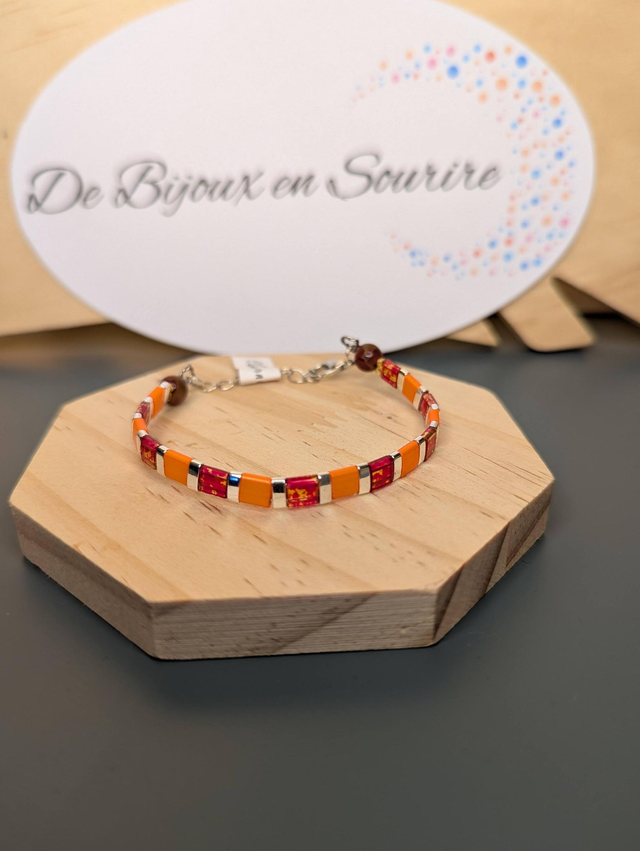 Bracelet en perles plate en verre orange et rouge, perles en métal argenté. le fermoir et la chaine fermoir sont en argent.
