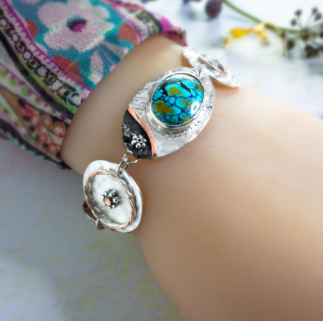 Pulsera artesanal en plata con turquesa iraní y detalles en cobre.