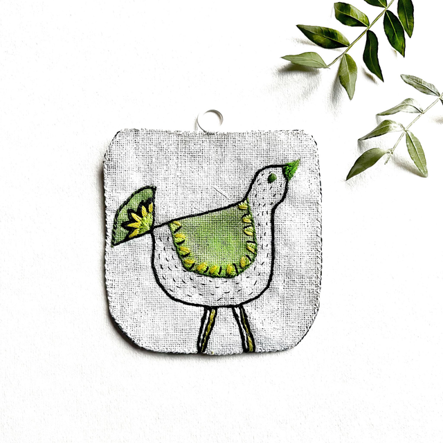Oiseau vert peint et brodé à accrocher