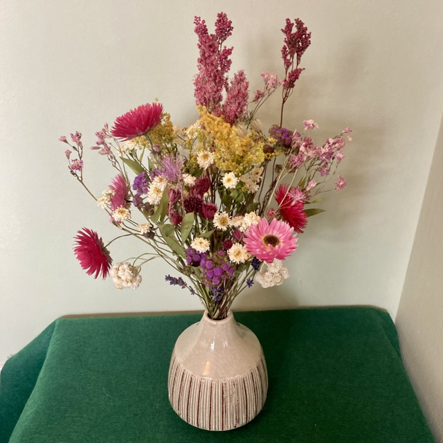 Local dried flower arrangement in vintage style green vase