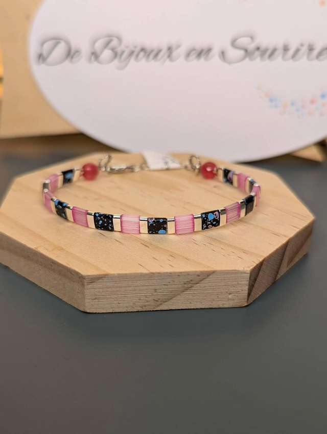 Bracelet en perles plate en verre rose et noire, avec des perles en métal argenté. Le fermoir et la chaine fermoir sont en argent.