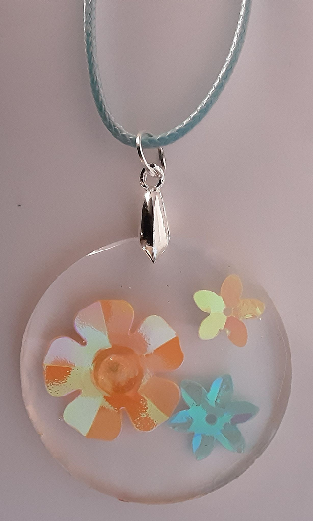 Pendentif rond collection Mouna Paillette transparent et fleur irisée orange bleue et rose cabochon scintillant