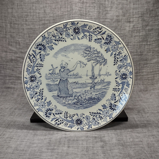 Boch Frêres | Sierbordje met ophanglus (diameter 21,5 cm | hoogte 2,3 cm) Delftsblauw met afbeelding &#039;Zwaaiend meisje in de haven&#039; | Vintage