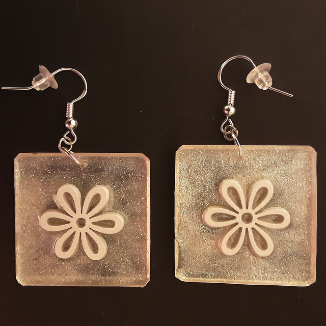 Boucle d’oreille carrée fond doré clair scintillant et fleur blanche en relief