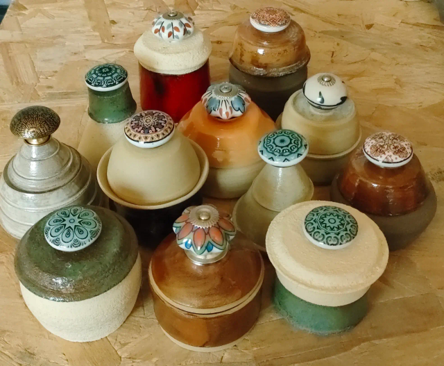  petites boîtes en céramique, entièrement tournées à la main, dont chaque couvercle est surmonté d’un bouton de tiroir en porcelaine