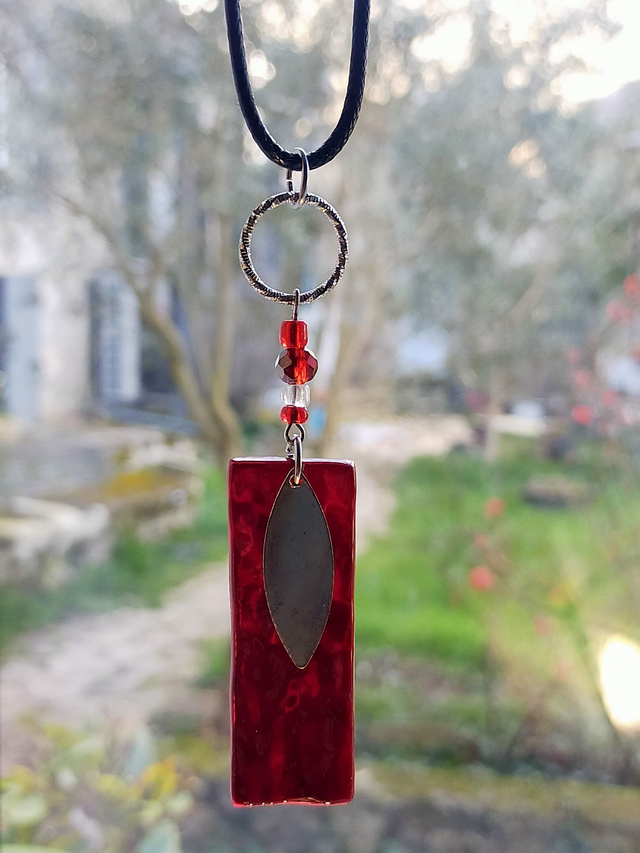 Pendentif en verre rouge cerise texturé et chaîne en coton ciré noir. 