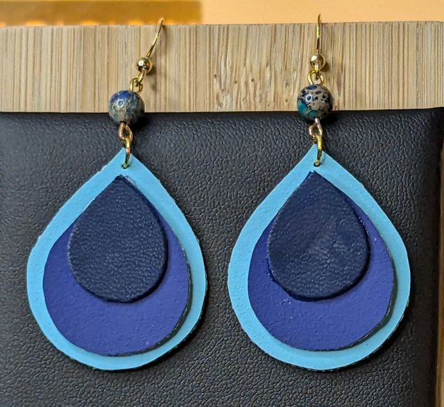 Boucles d'oreilles pendante en similicuir et en tissus enduit dégradé bleu. Perles naturelles, fermoir de couleur or.