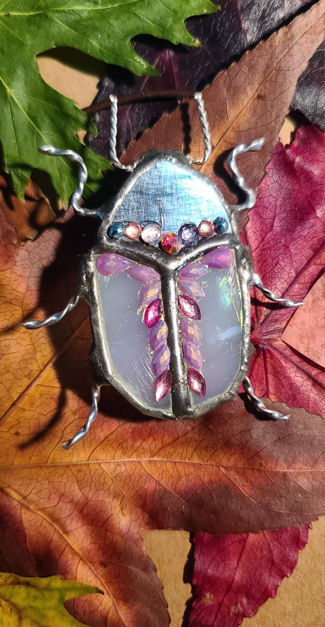 Scarabée en Tiffany, au corps blanc iridescent et à la tête argentée  monté en broche.