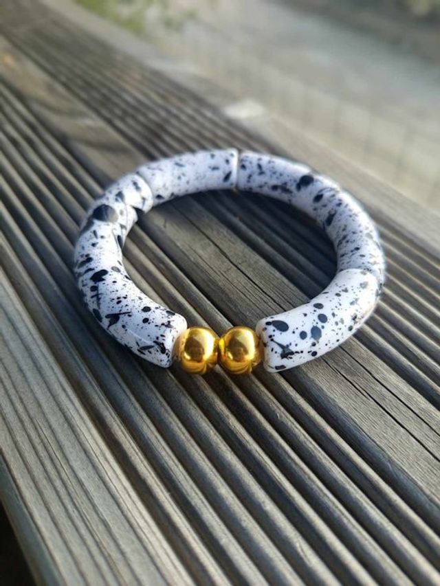 Bracelet perles tubes incurvées acryliques tâchetées Khazaana blanc et noir