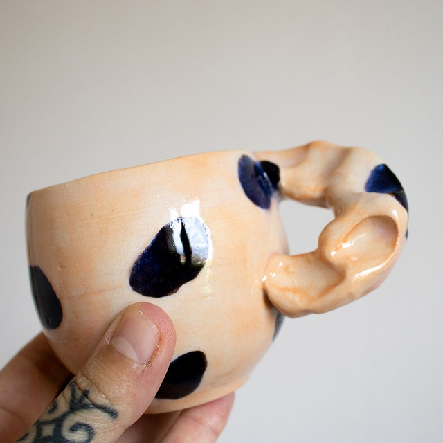 Tasse orange tâches noires, anse biscornue