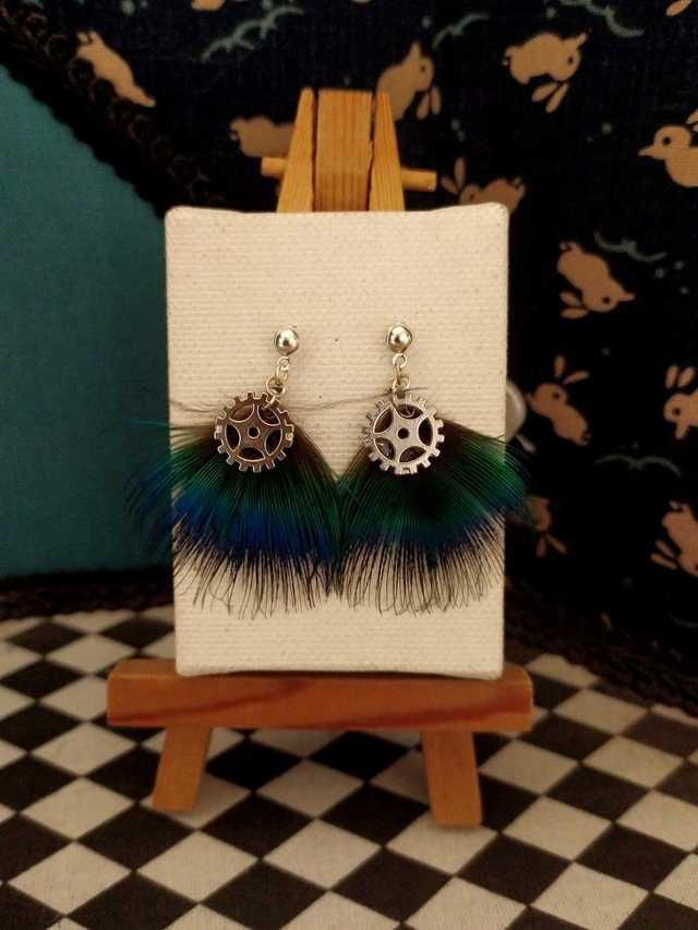 Clous d'oreilles argenté plumes de paon bleues et breloques