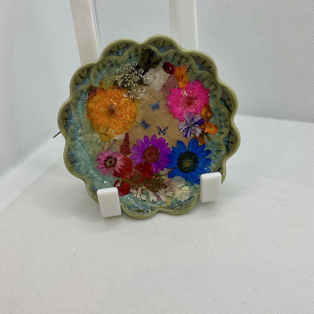 Green ring trinket tray with pressed flowers and resin.