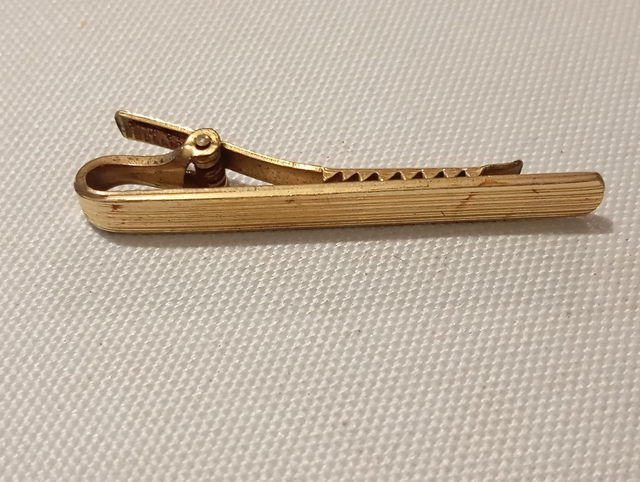 Pince à cravate dorée pincée