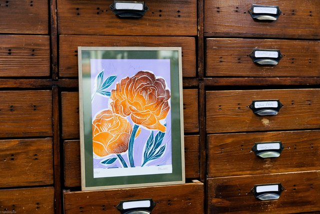 Couple de pivoines orange sur fond violet pâle vif avec cadre sous verre finition kraft gommé