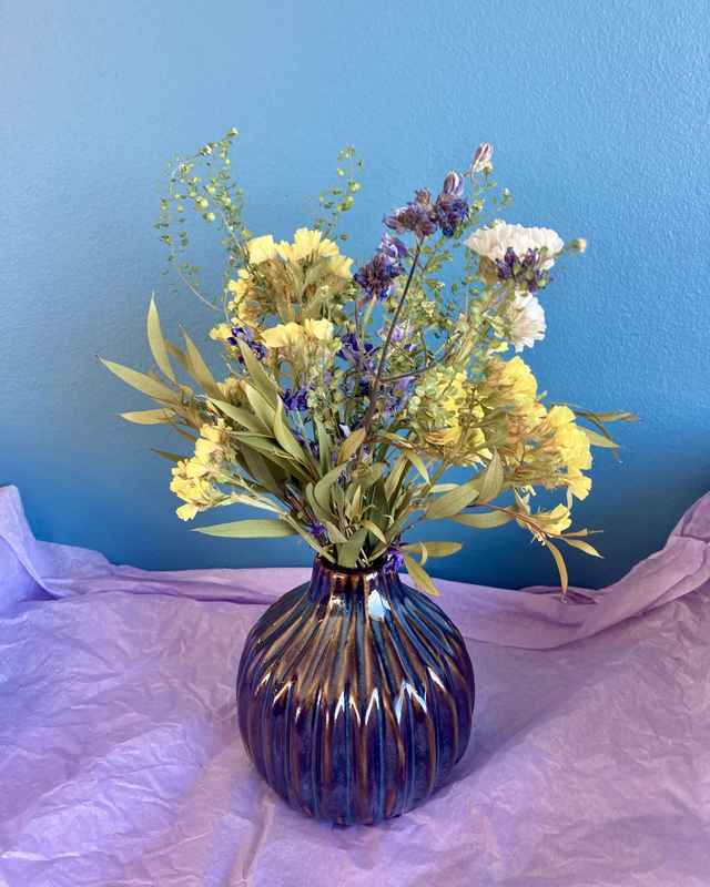 Local dried flower arrangement in dark blue glazed vase