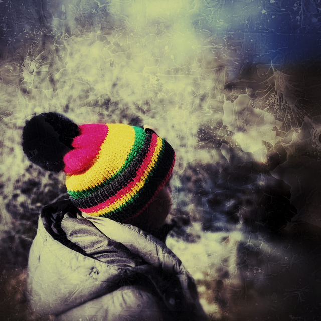 Adult beanie. Black, red, green and yellow with removable faux fur pom