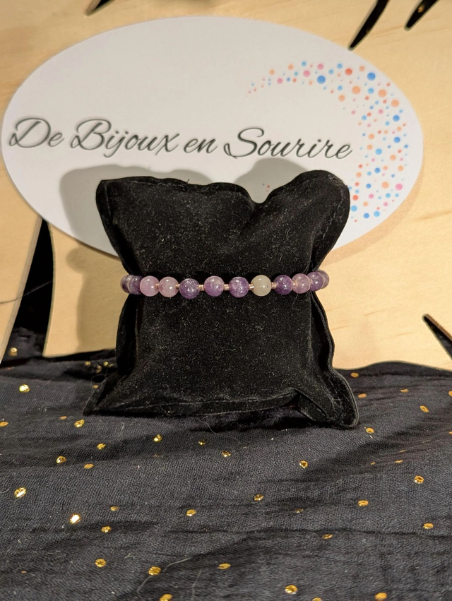 Bracelet en perles de lépidolite violette, et des perles d'espacement violette. Le fermoir et la chaine fermoir sont de couleur or.