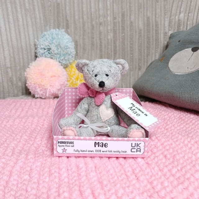 Mae. Miniature size, handmade teddy bear. UKCA. Tray base packaging. Standard Wool Felt. Grey. Pink.