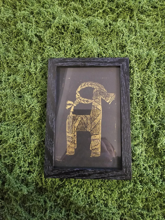 Bouc de yule d'or sous cadre 