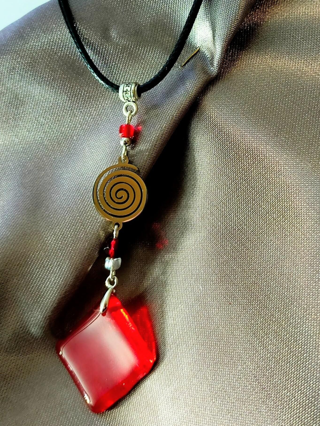 Pendentif en verre rouge et chaîne en coton ciré noir.