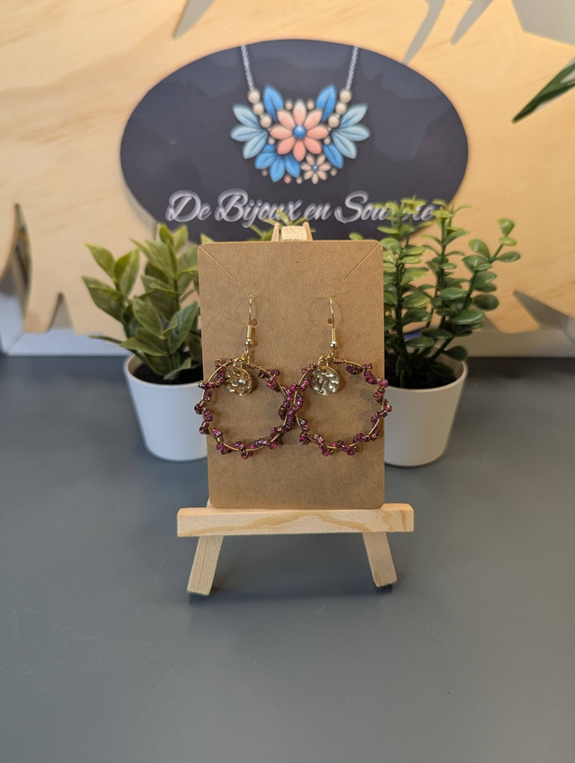 Petites créoles avec perles en verre violette et pendentif rond de couleur or. 