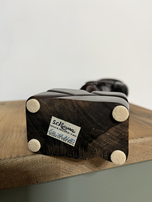 Wooden statue of a Filipino female farmer, with a hat, holding harvested rice.