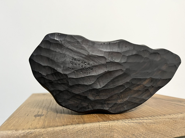 Wooden sculpture of a man feeding a rooster from Tantra Mas Bali Gallery.